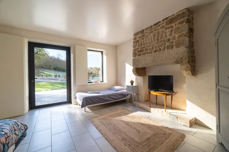 Chambre avec cheminée en pierre et parquet — Photo immobilière Click&Com