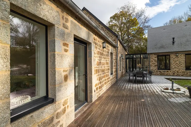 Extérieur maison en pierre avec terrasse bois — Photo immobilière professionnelle Click&Com